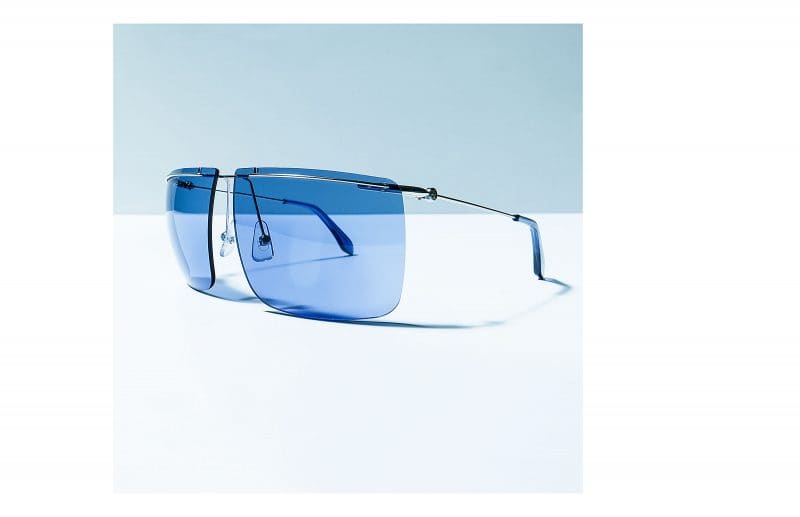 Sonnenbrille mit blauen Gläsern auf weißblauem Untergrund . Calvin Klein