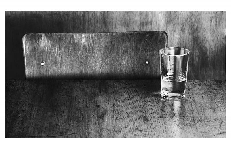 Wasserglas steht auf einem Holztisch